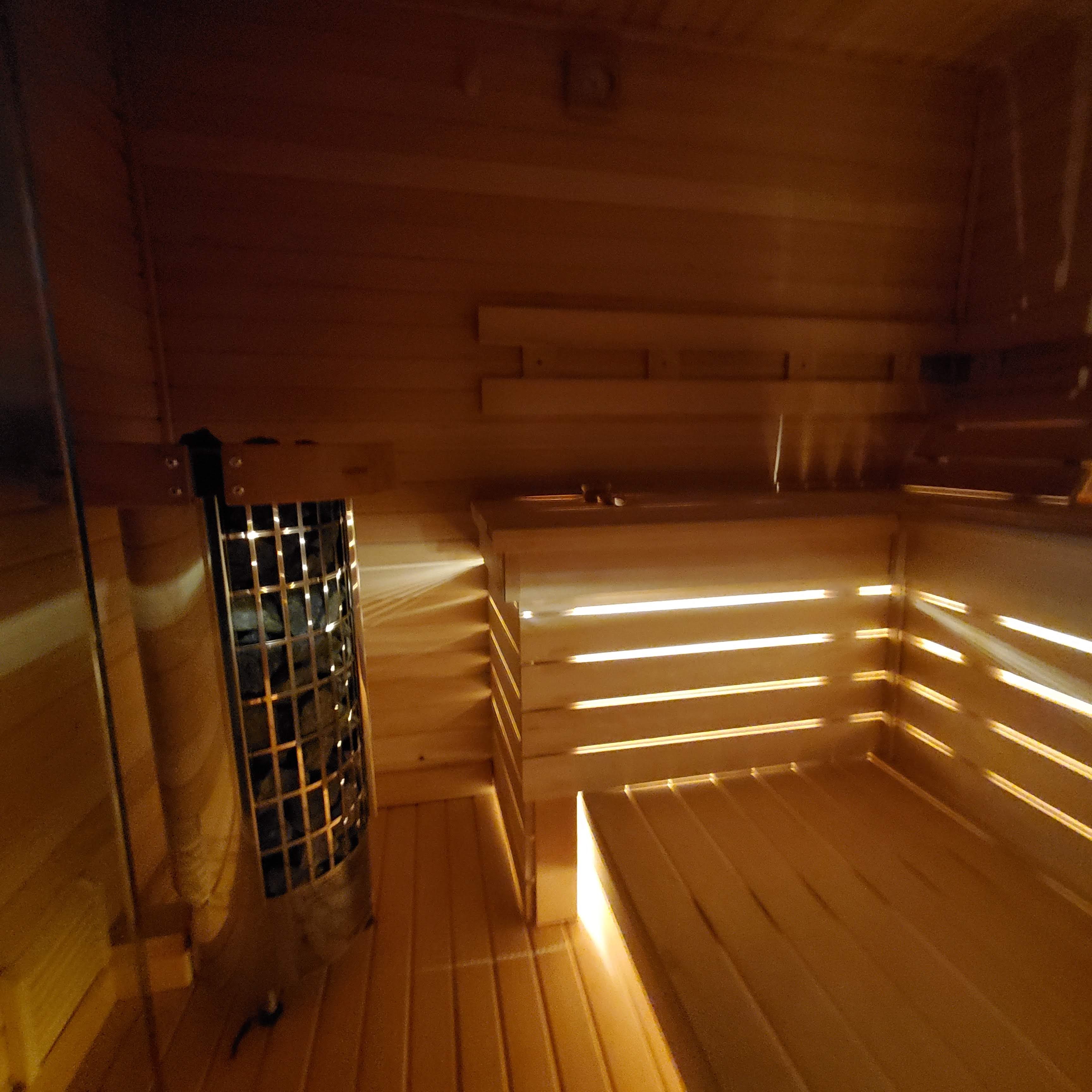 Sauna interior with wall-mounted heater and backlighting