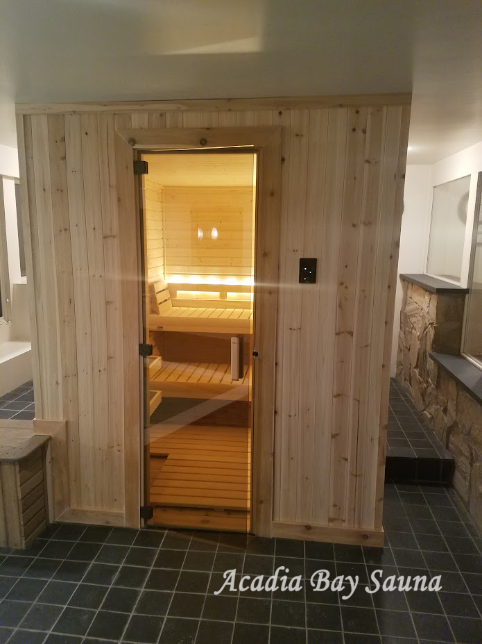 Residential sauna with glass door and stone accent