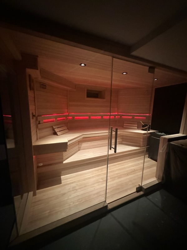 Glass-enclosed sauna with red LED lighting
