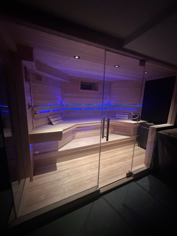 Glass-enclosed sauna with blue LED lighting