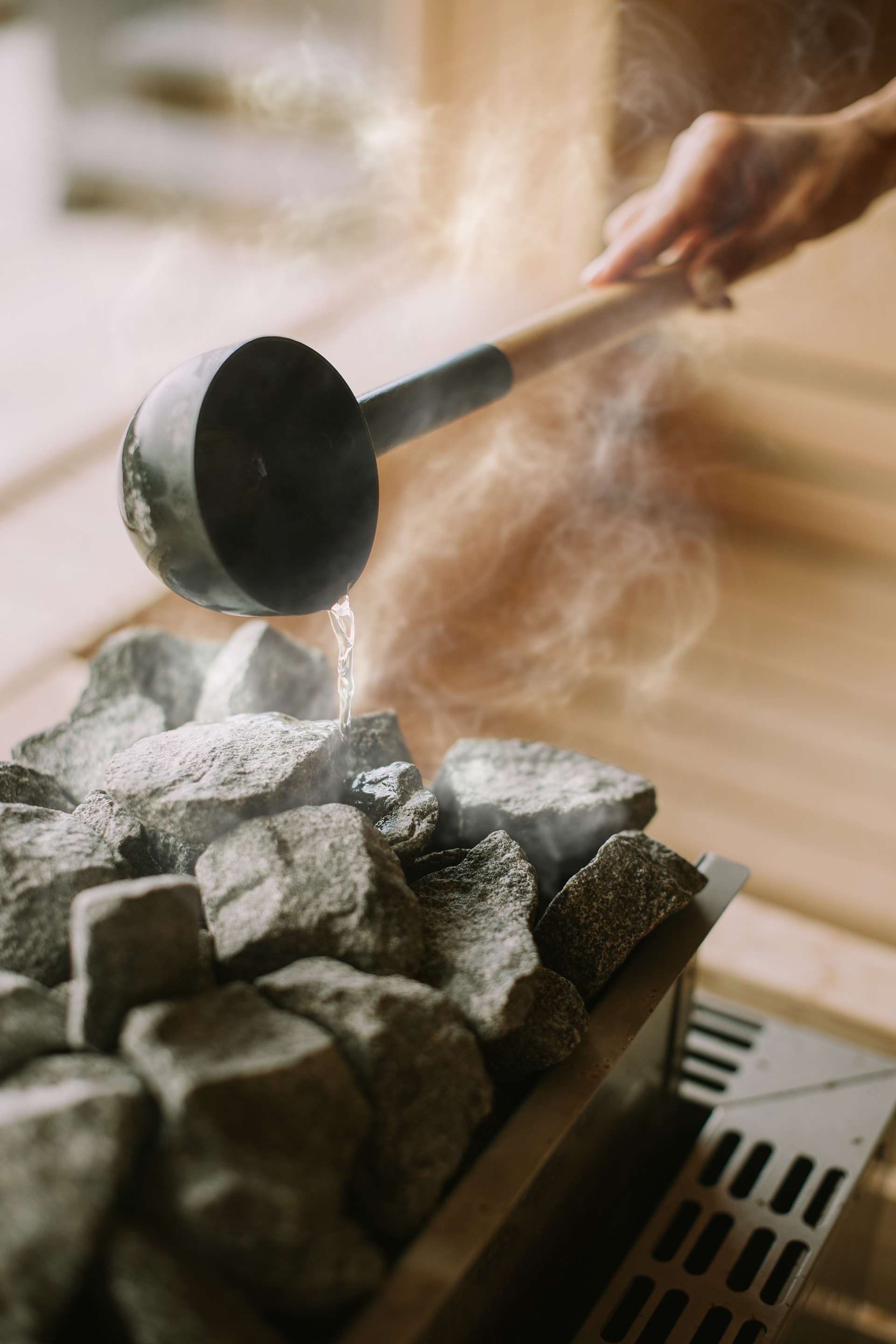 Pouring water over hot sauna stones